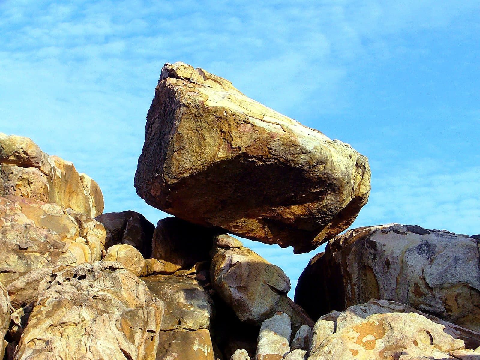 Weathered granite boulders on the shore of Pulau Redang against a bright blue sky